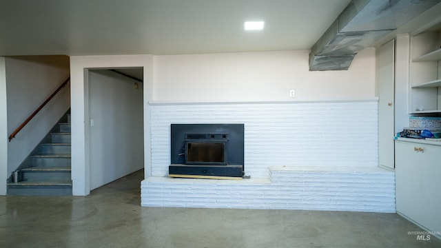 unfurnished living room featuring stairs and concrete floors