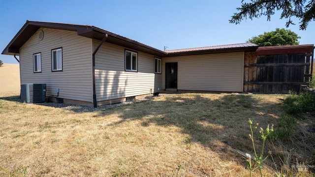 back of house with fence, central AC, and a yard