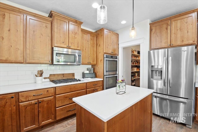 1041 White Horse Ridge Dr, Middleton, ID 83644 - kitchen featuring appliances with stainless steel finishes, backsplash, wood finished floors, and light countertops