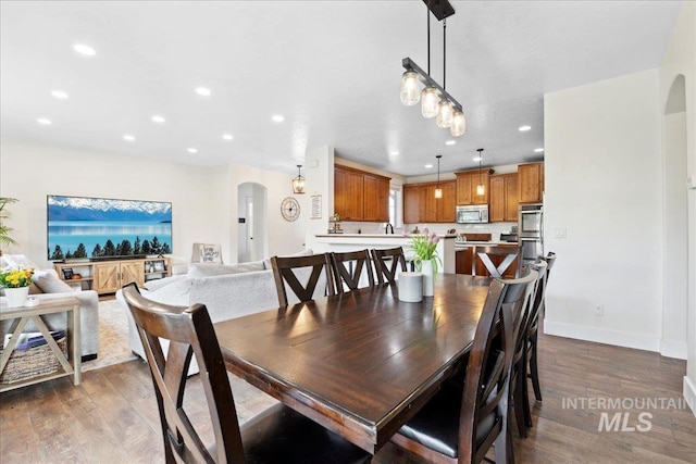 1041 White Horse Ridge Dr, Middleton, ID 83644 - dining space with arched walkways, recessed lighting, wood finished floors, and baseboards