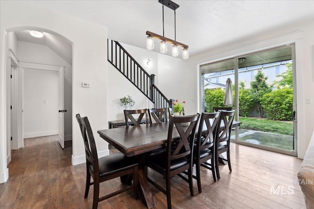 1041 White Horse Ridge Dr, Middleton, ID 83644 - dining area featuring hardwood / wood-style floors, stairway, arched walkways, and baseboards