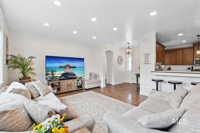 1041 White Horse Ridge Dr, Middleton, ID 83644 - living room featuring arched walkways, dark wood-style floors, recessed lighting, and baseboards