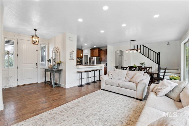 1041 White Horse Ridge Dr, Middleton, ID 83644 - living area with dark wood finished floors, arched walkways, recessed lighting, baseboards, and stairs