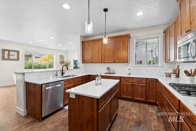1041 White Horse Ridge Dr, Middleton, ID 83644 - kitchen with appliances with stainless steel finishes, a sink, a peninsula, backsplash, and recessed lighting