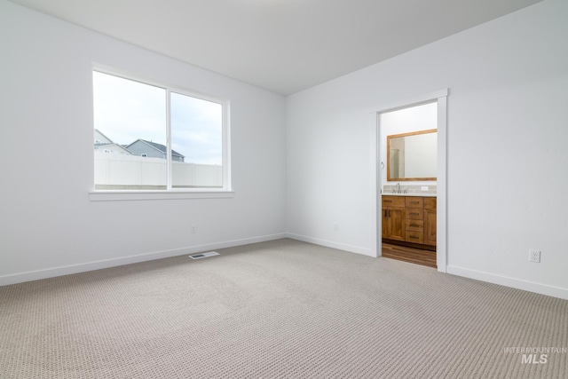 unfurnished room featuring sink and carpet