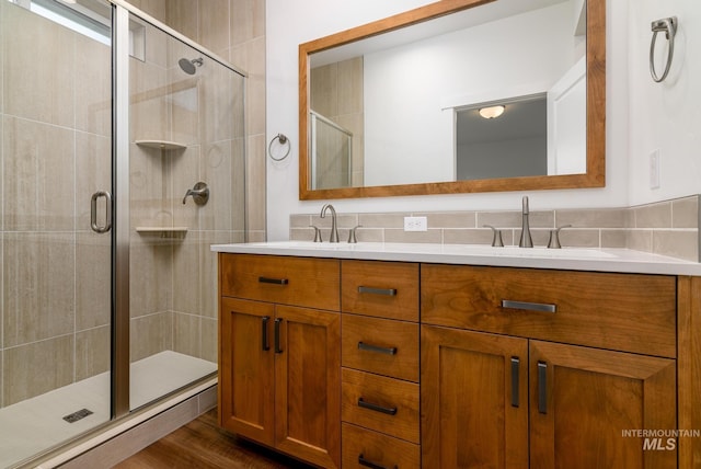 bathroom featuring vanity, an enclosed shower, tasteful backsplash, and hardwood / wood-style floors