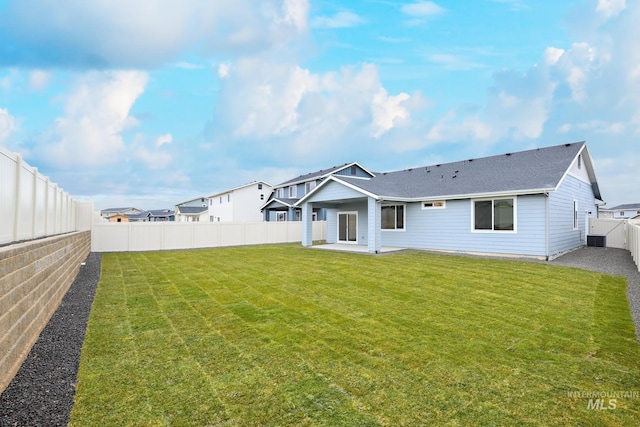 rear view of house with a yard, central AC unit, and a patio area