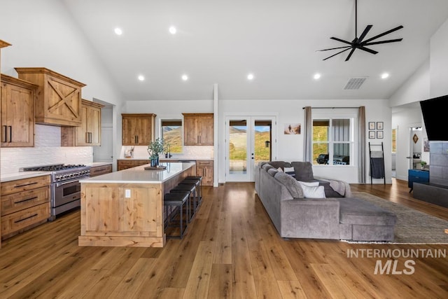 5251 Hidden Hollow Ln, Emmett, ID 83617 - kitchen with stainless steel stove, open floor plan, high vaulted ceiling, a breakfast bar, and a kitchen island