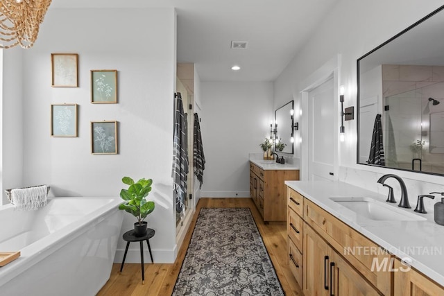5251 Hidden Hollow Ln, Emmett, ID 83617 - full bath featuring two vanities, a stall shower, wood finished floors, a freestanding bath, and recessed lighting