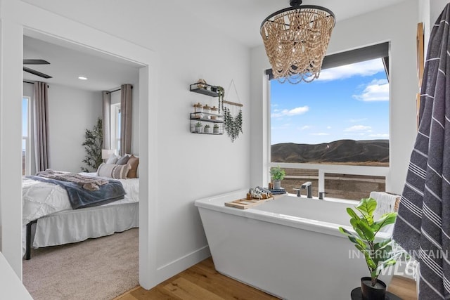 5251 Hidden Hollow Ln, Emmett, ID 83617 - ensuite bathroom with a freestanding tub, wood finished floors, a mountain view, a chandelier, and recessed lighting