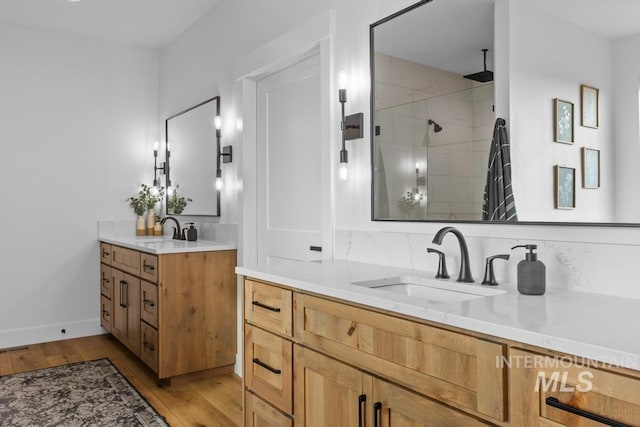5251 Hidden Hollow Ln, Emmett, ID 83617 - bathroom featuring a stall shower, two vanities, and wood finished floors