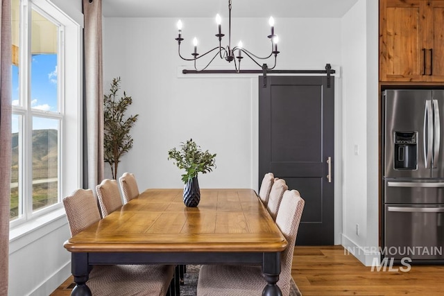 5251 Hidden Hollow Ln, Emmett, ID 83617 - dining room with a chandelier, light wood-style floors, and a barn door
