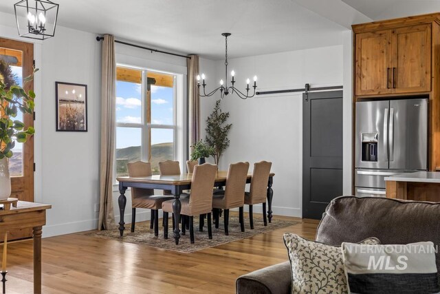 5251 Hidden Hollow Ln, Emmett, ID 83617 - dining room featuring a chandelier, light wood-style floors, and a barn door