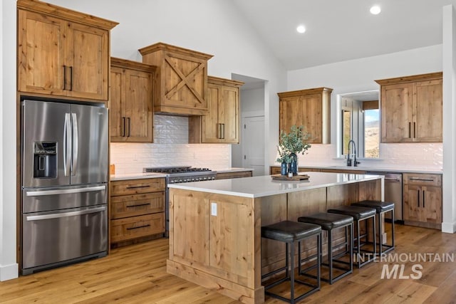 5251 Hidden Hollow Ln, Emmett, ID 83617 - kitchen with appliances with stainless steel finishes, a center island, light countertops, a breakfast bar area, and decorative backsplash