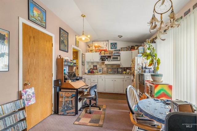 carpeted home office featuring lofted ceiling