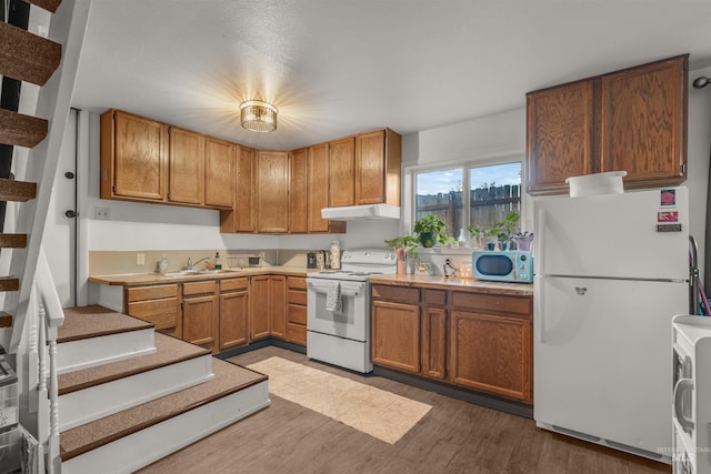 kitchen featuring dark wood-type flooring, sink, and white appliances