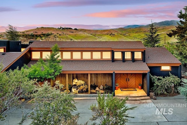 view of front of property with a mountain view and roof with shingles