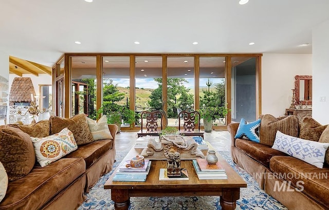 living area with beamed ceiling, recessed lighting, and a wall of windows