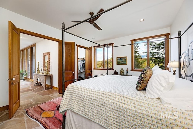 bedroom featuring recessed lighting, stone finish floor, baseboards, and a ceiling fan