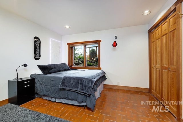 bedroom with brick floor, baseboards, and recessed lighting