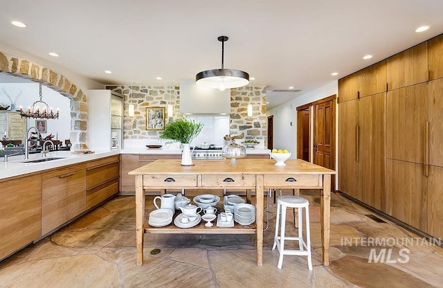 kitchen featuring visible vents, modern cabinets, pendant lighting, a sink, and light countertops