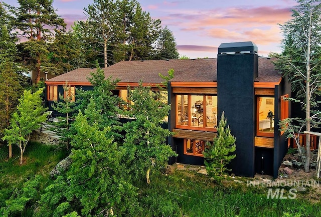 back of house featuring a chimney