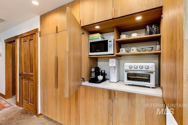 bar featuring visible vents, a toaster, white microwave, and recessed lighting