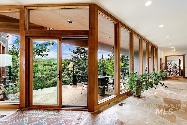 doorway with stone tile floors, recessed lighting, and visible vents