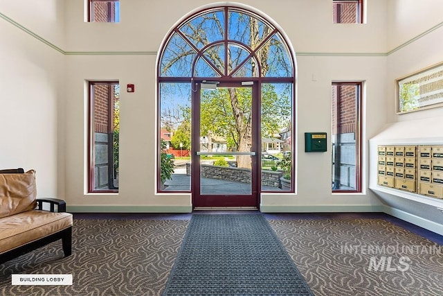 interior space with carpet flooring, a towering ceiling, and baseboards
