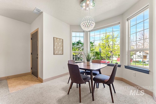 dining room with a chandelier, light colored carpet, baseboards, and plenty of natural light
