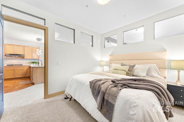 bedroom with light colored carpet and a sink