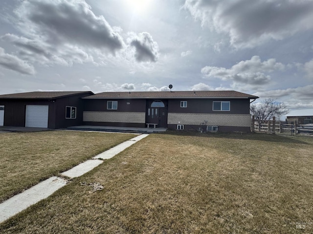 back of house with an attached garage, a yard, and fence