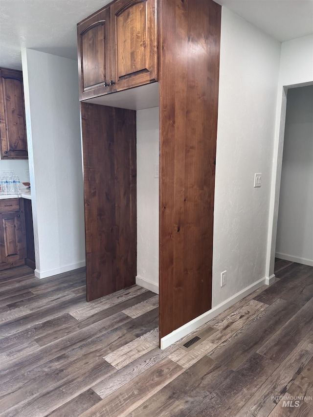 kitchen featuring light countertops, dark wood-style flooring, and baseboards