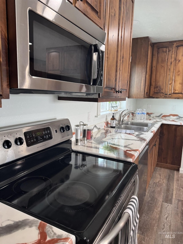 kitchen with wood finished floors, a sink, and appliances with stainless steel finishes