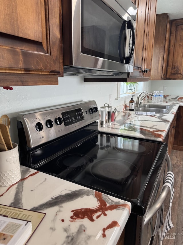 kitchen with a sink, appliances with stainless steel finishes, and wood finished floors