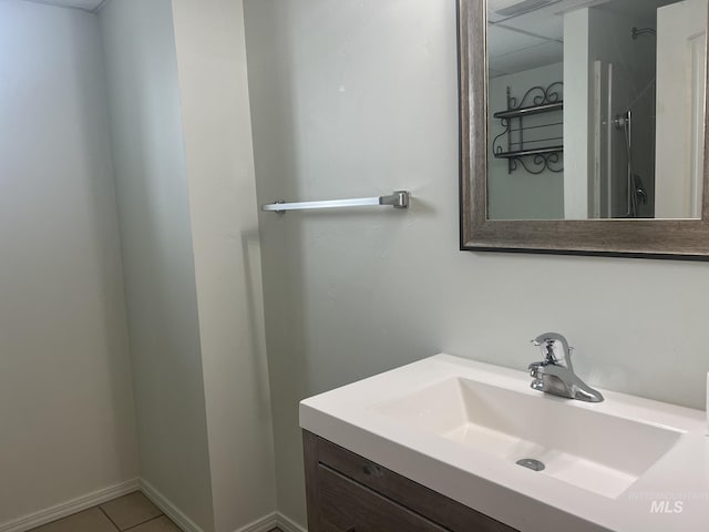 bathroom with tile patterned flooring, vanity, and baseboards
