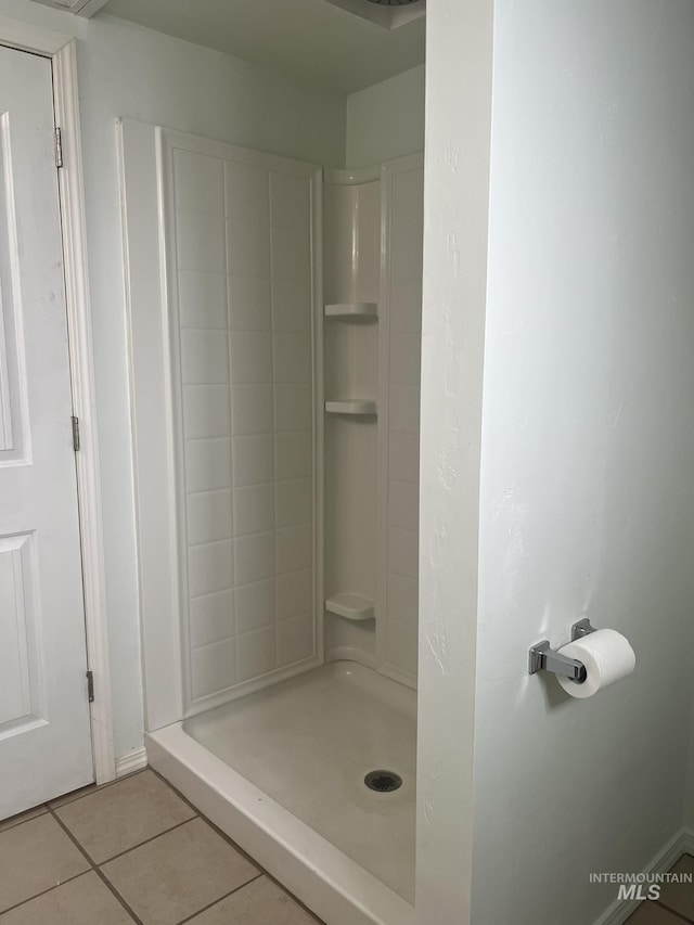 bathroom with tile patterned floors and a stall shower