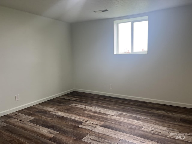 empty room with baseboards and dark wood finished floors
