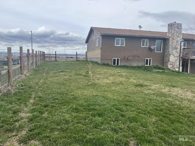 back of property with fence and a lawn
