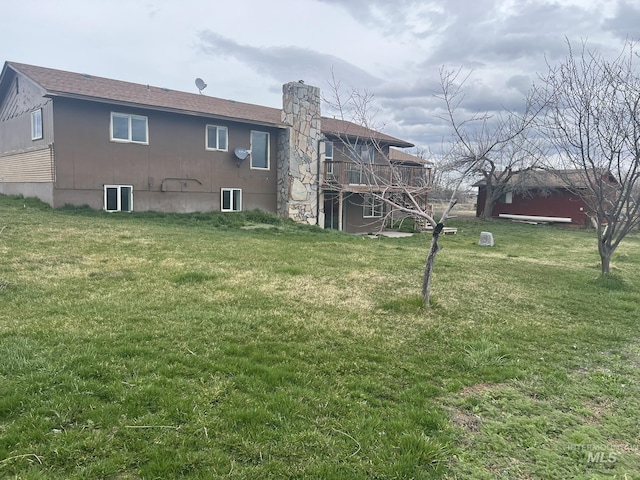 back of house featuring a yard and a chimney