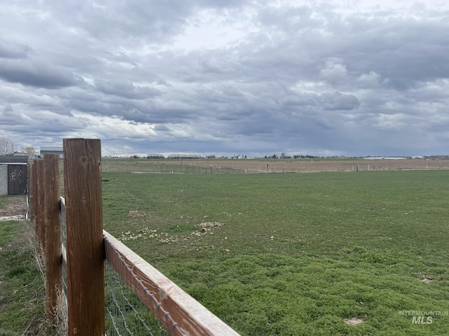 view of yard featuring a rural view and fence