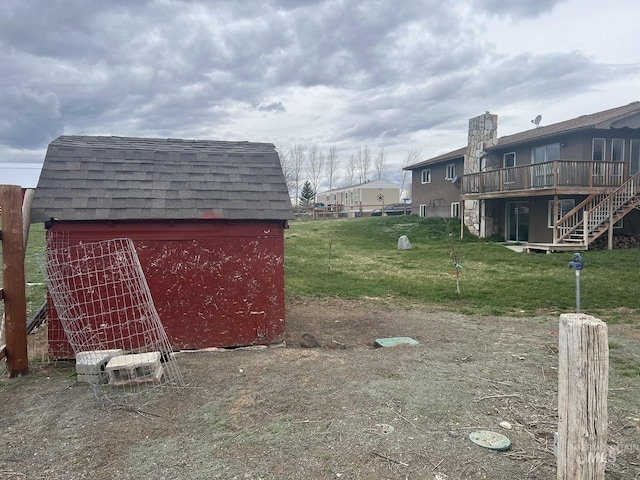 view of yard featuring a deck, an outdoor structure, and a storage unit