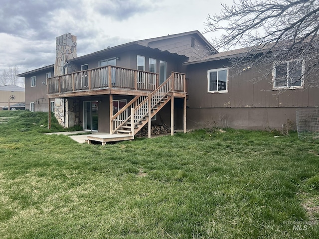 back of property featuring stairs, a wooden deck, and a lawn