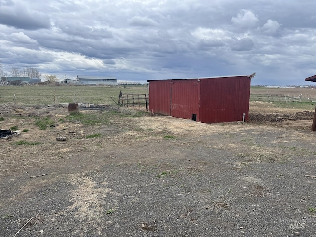 view of pole building with a rural view and fence