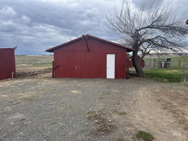 view of pole building featuring a rural view and fence