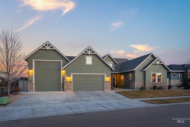 craftsman inspired home with concrete driveway, an attached garage, stone siding, and a front yard