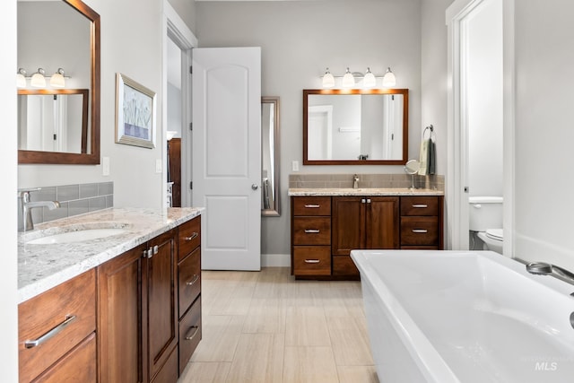 full bath with decorative backsplash, toilet, and a sink