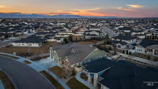 aerial view at dusk with a mountain view and a residential view