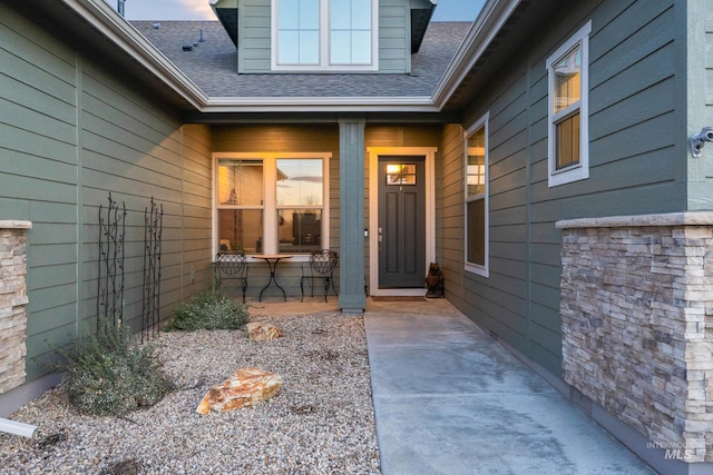 property entrance featuring a shingled roof