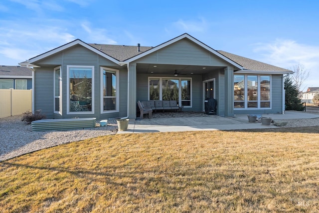 back of property with a ceiling fan, a patio area, fence, and a lawn